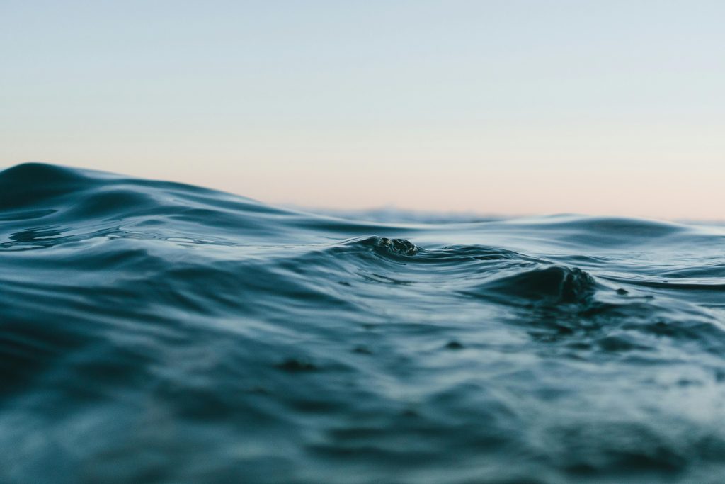 A picture of waves against a steel grey sky.  From the angle, it looks like the photographer is about to go underwater.